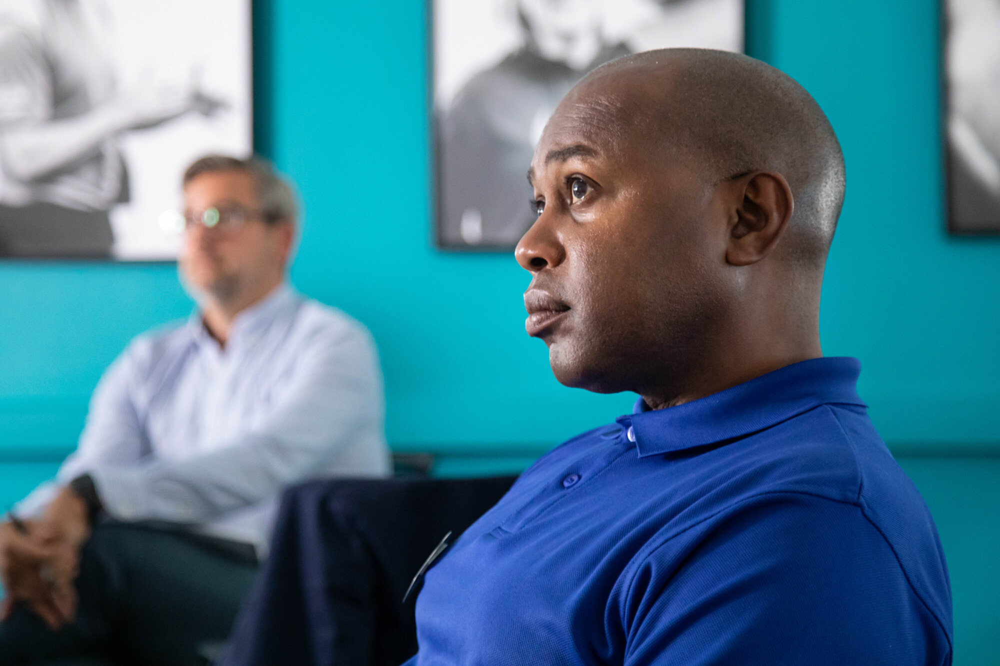 Close up of personal safety trainer Sam in the IKON training room watching a presentation on the big screen.