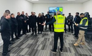James standing in front of a group of learners, he is wearing an IKON branded hi vis jacket. Security Safety Training.